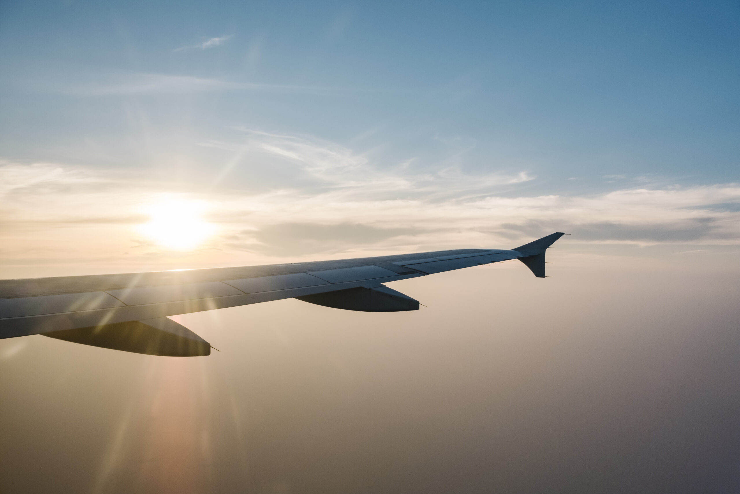 airplane wing and sunset on blue sky